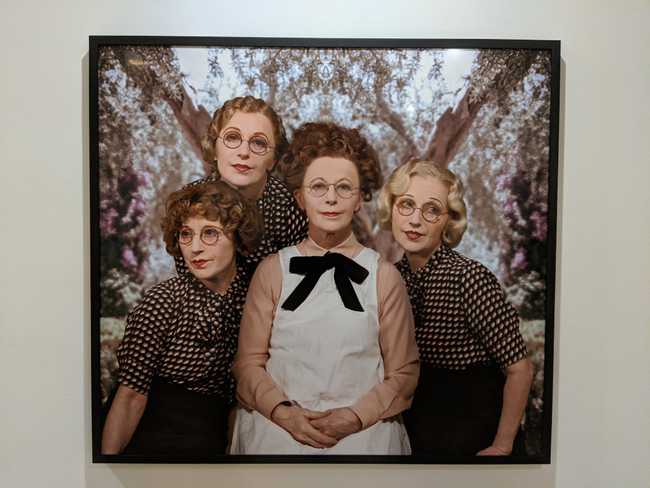 A photo of the same woman in four different portraits and outfits.
It's composited together to look like a family
photo.