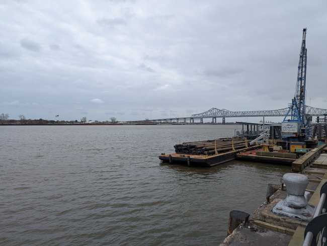 A wide river with a bridge in the distance. It has an industrial feel.