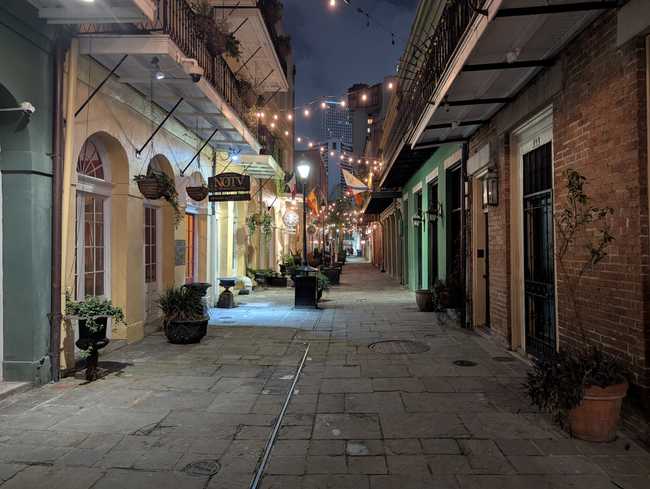 A narrow alley with crisscrossing strings of lights.