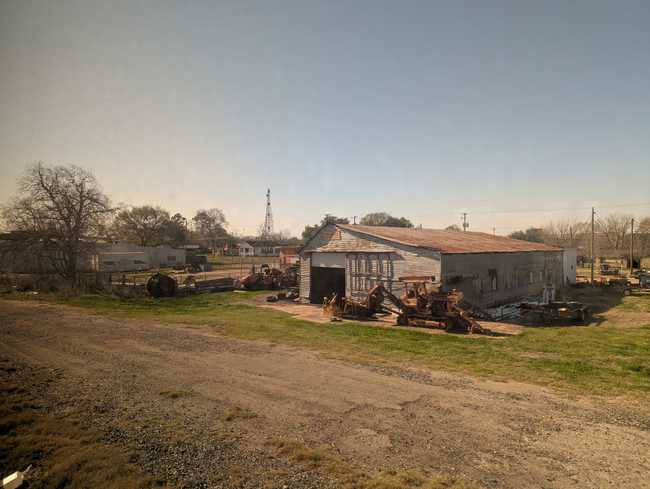 A ramshackle old building on a dirt road.