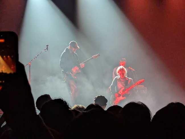 A close up of the lead guitarist and the front-woman. He's soloing, and she's playing off
him.