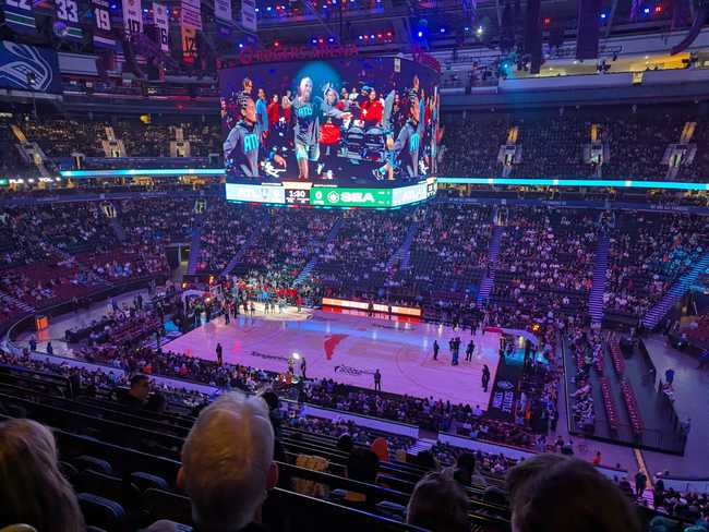Inside Rogers Arena, set up for basketball. The lights are dimmed. There's a spotlight on a corner of the court,
where the Atlanta Dream players are entering.