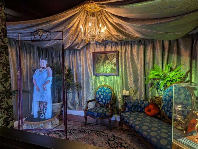 A recreation of a bordello, with a hologram sex worker showing her legs.