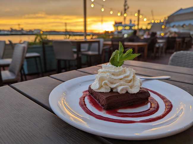 A fancy-looking dessert with a blurry waterfront background.