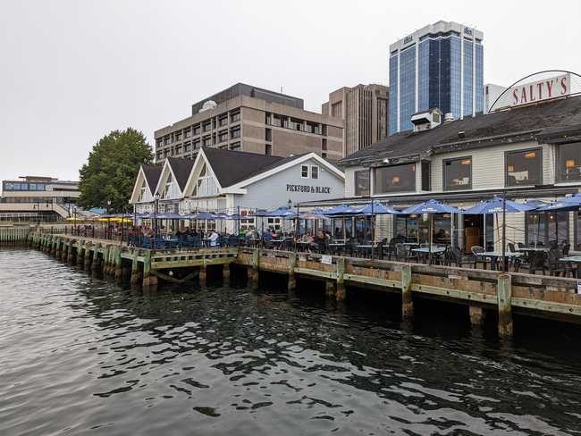An old quayside with restaurants and outdoor seating.
