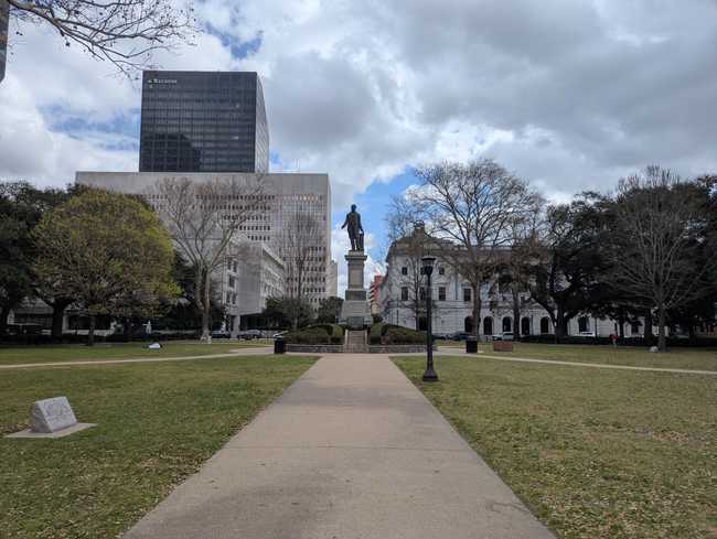 A grassy square with a statue in the middle.
