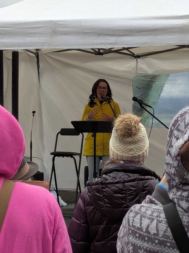 A close up of a woman speaking to the crowd.