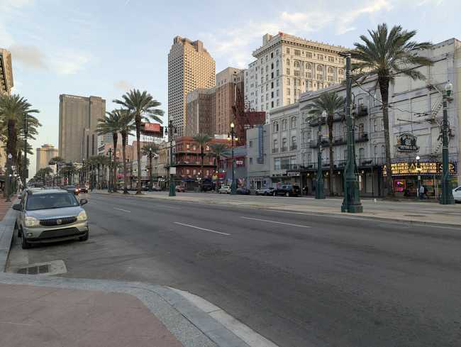 A boulevard with palm trees down the median.