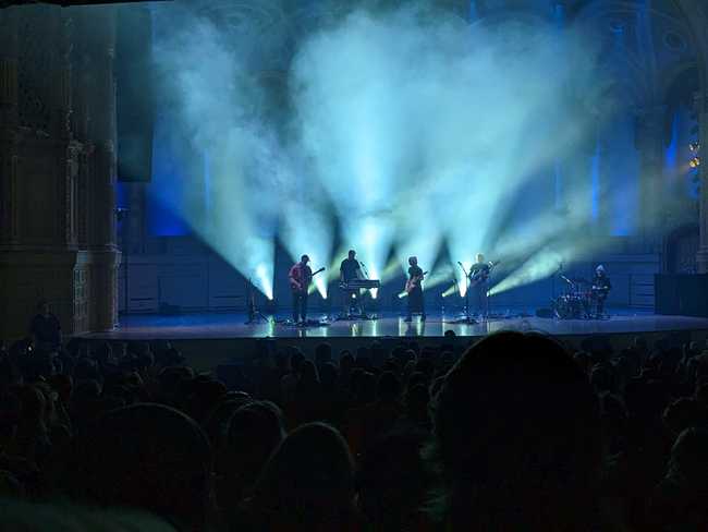 Men I Trust, silhouetted by flood lights