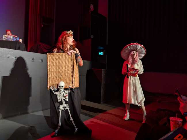 Two performers (including the one dressed as a mushroom) walking in front of the audience.