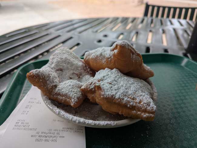 Three squares of fresh dough on a plate, covered in baking sugar.