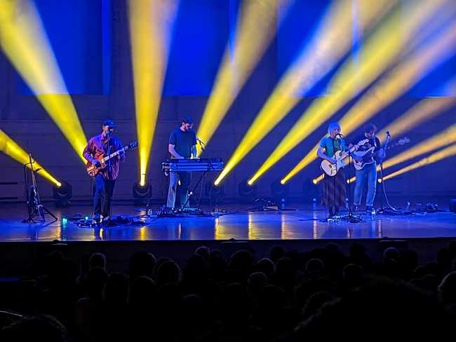 Men I Trust, lit in blue with yellow flood lights