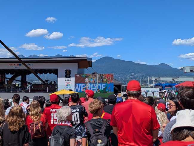The same crowd, but now facing the screen. On the left is the outdoor stage used for TSN broadcasts. In the distance
are the north shore mountains. It's gorgeously sunny.